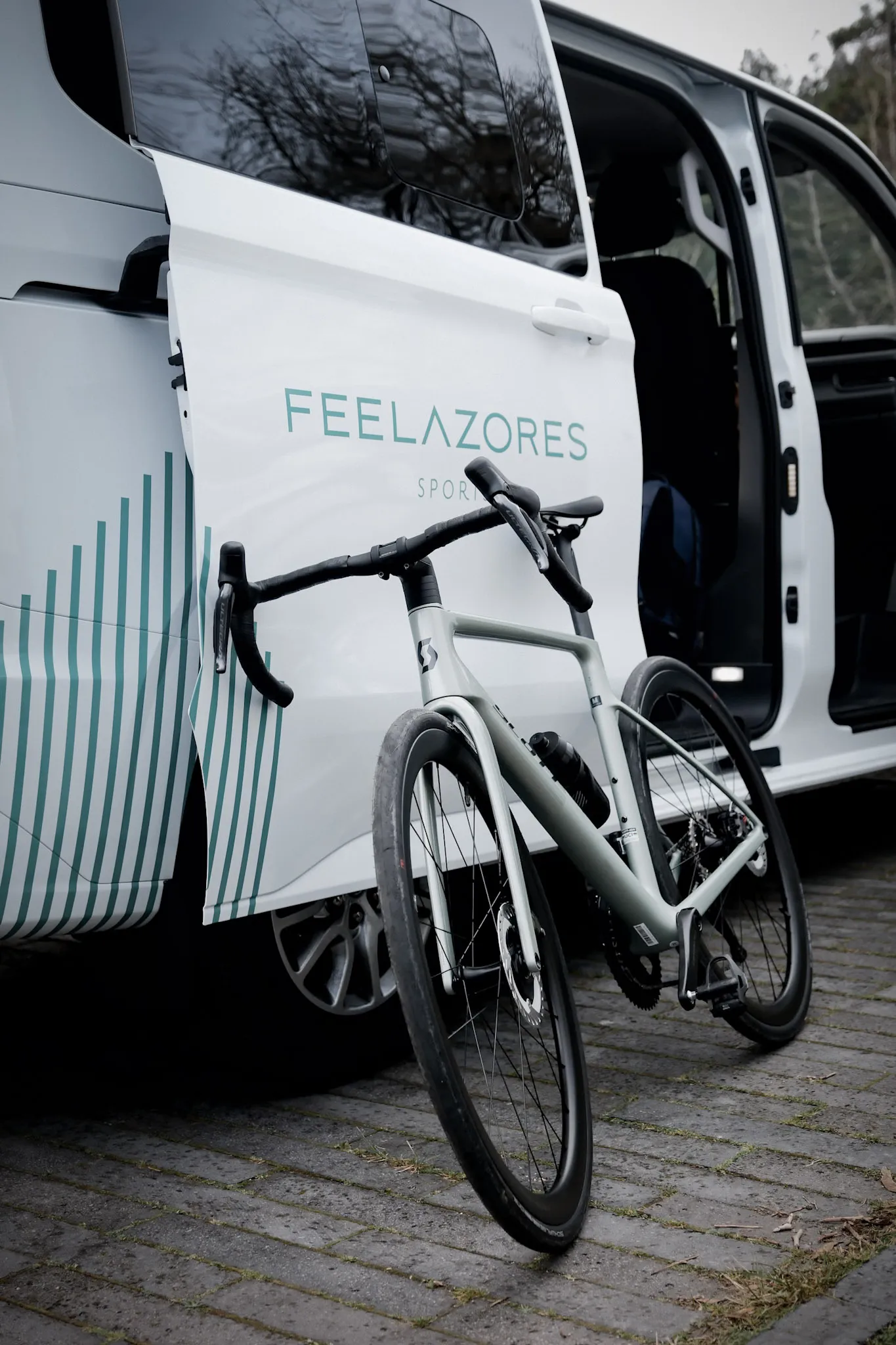 Ciclista com bicicleta de estrada junto ao mar.